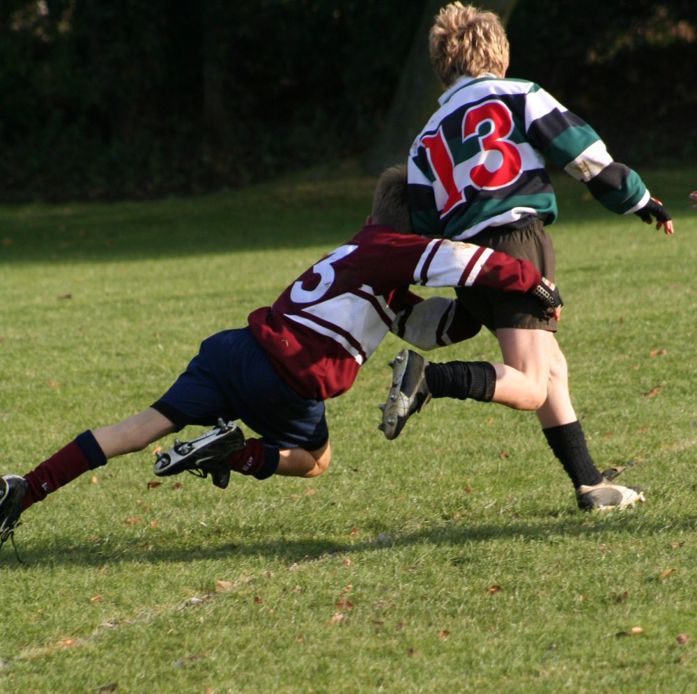 Twee jeugdspelers in een rugbytackle